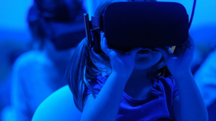 A young girl with a virtual reality headset, engaged in an immersive digital environment.