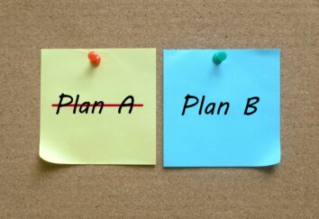 Two sticky notes are attached to a board, with one saying plan A and the other Plan B