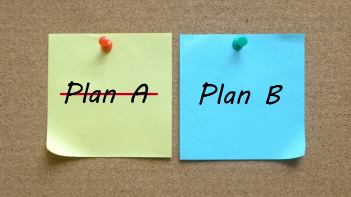 Two sticky notes are attached to a board, with one saying plan A and the other Plan B