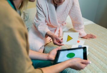 Two people look down on two stickers with various shapes