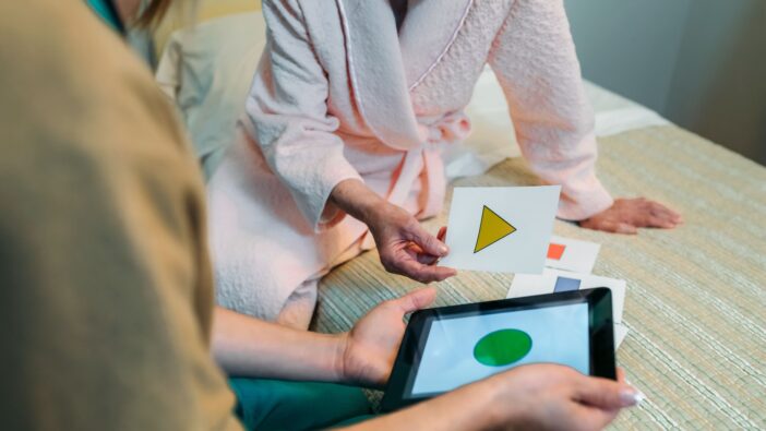 Two people look down on two stickers with various shapes