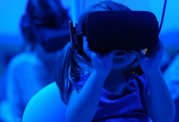 A young girl with a virtual reality headset, engaged in an immersive digital environment.