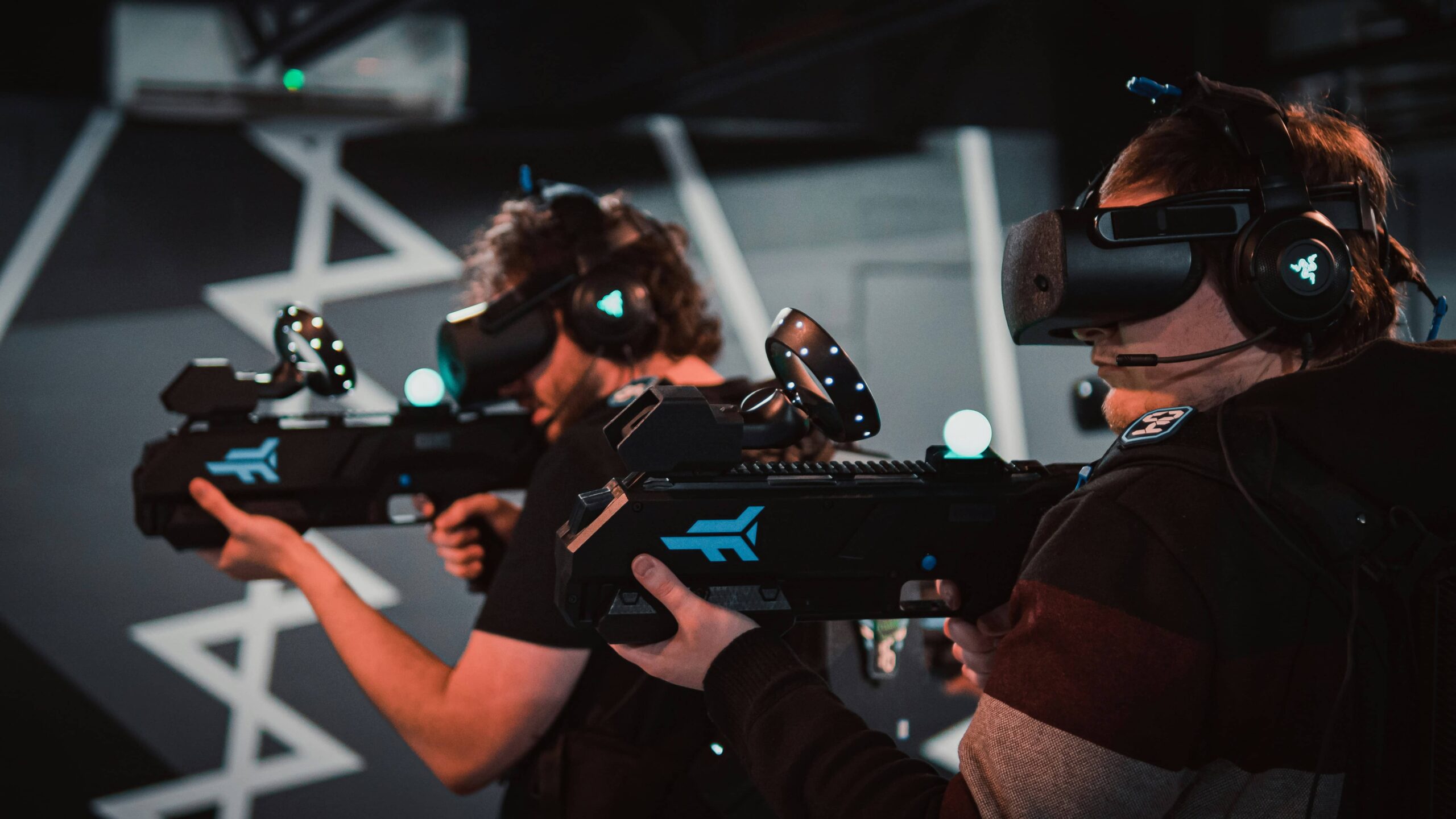 Landscape image of two men engrossed in a VR shooting game
